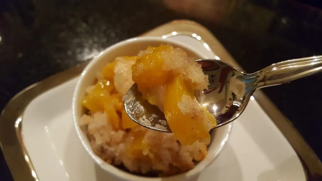 Old Fashioned Peach Cobbler serving with a bite on a spoon