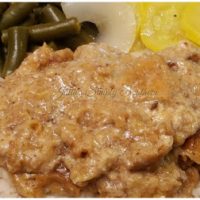 country style steak on a plate with squash and green beans