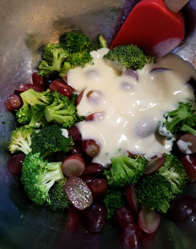 preparing broccoli salad in a mixing bowl