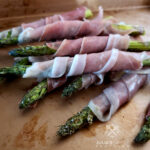 Asparagus Wrapped in Prosciutto on a sheet pan serving tray
