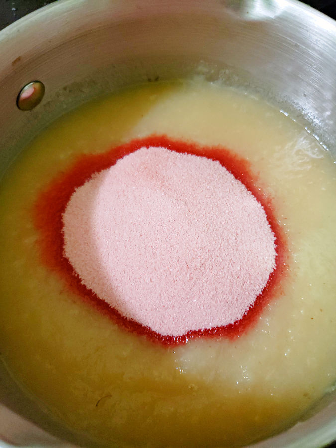 adding strawberry gelatin to boiling applesauce