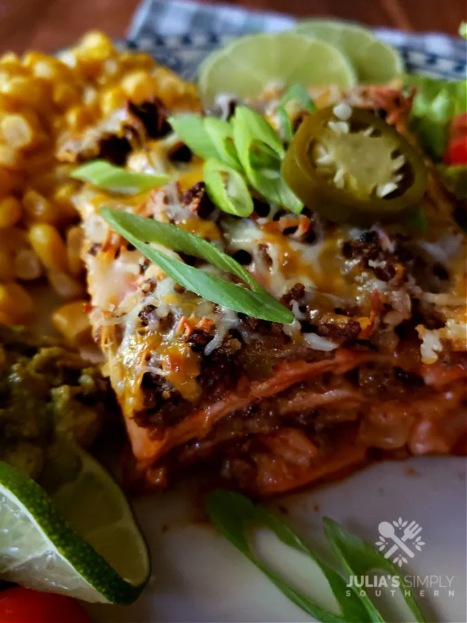 Delicious Enchilada Casserole Recipe garnished with scallions and a sliced pickled jalapeno