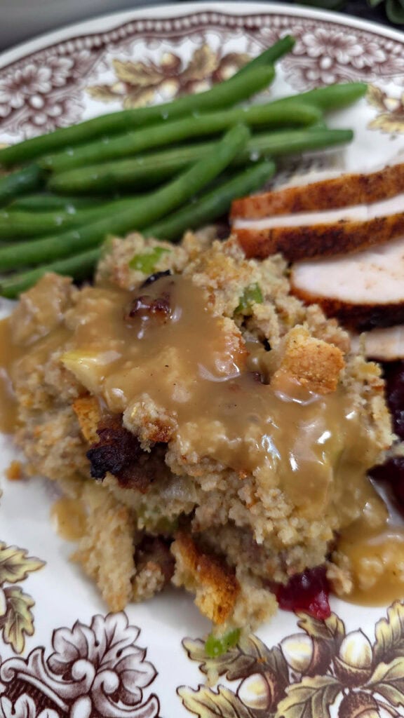 Thanksgiving china with cornbread dressing, turkey slices, and green beans