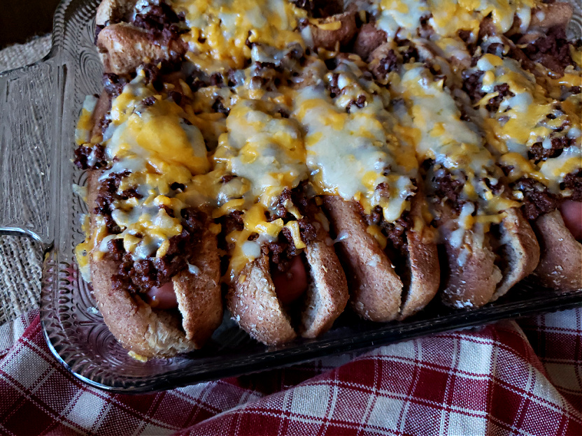 Oven Baked Chili Cheese Hot Dogs in a casserole dish