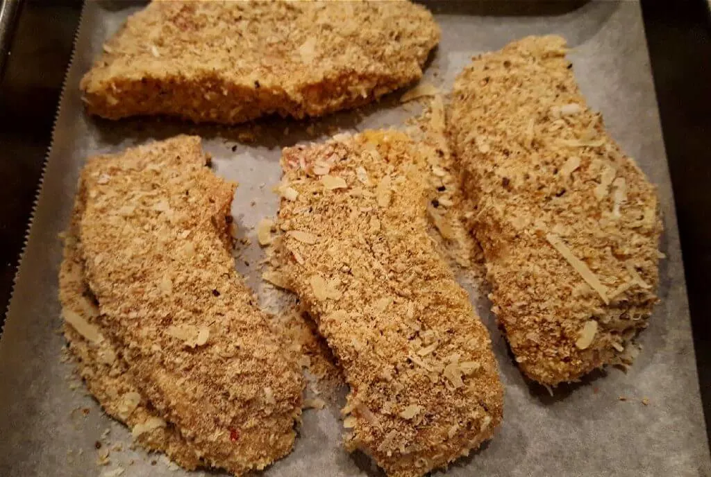 Pork chops on a sheet pan before baking