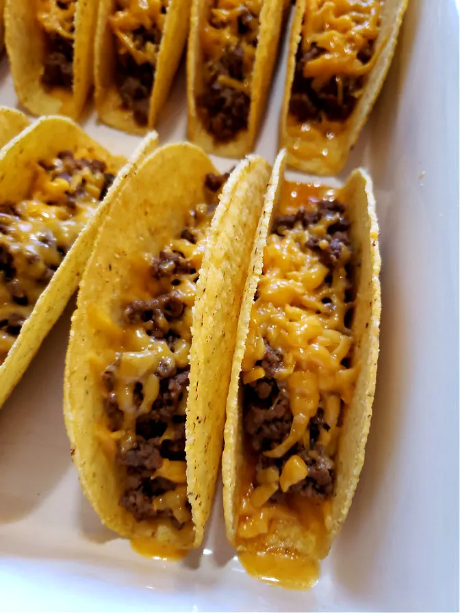 Baked tacos with ground beef and cheddar cheese in hard shells.
Easy Cheesy Oven Baked Tacos.