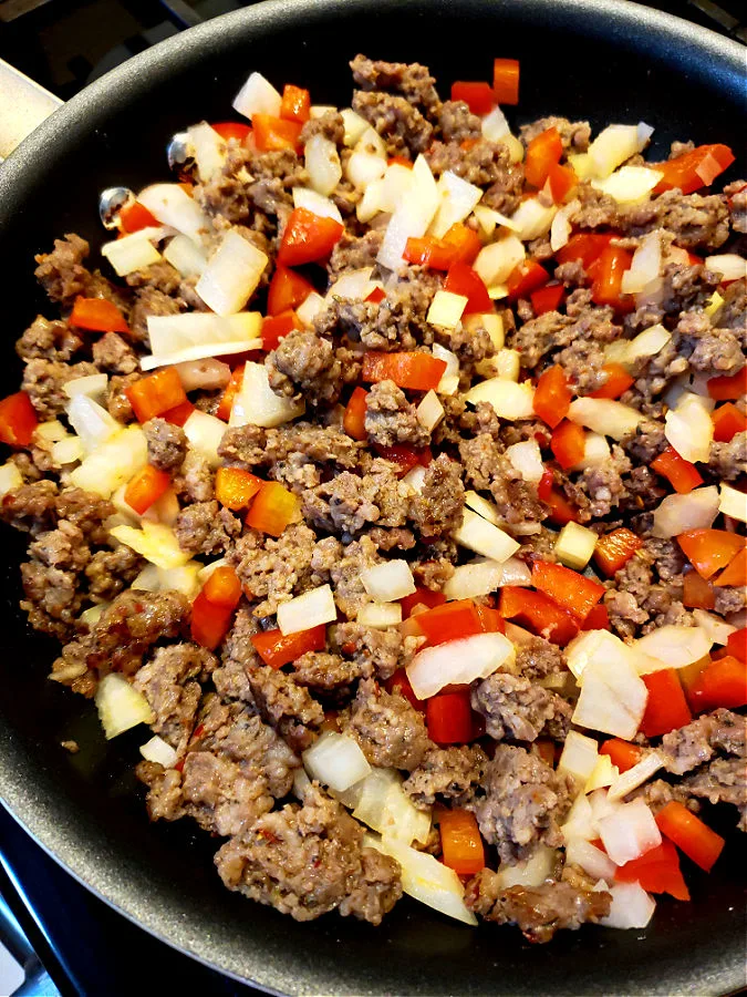 cooking Jimmy Dean Sausage, Red Pepper and Yellow Onion in a skillet for easy breakfast casserole