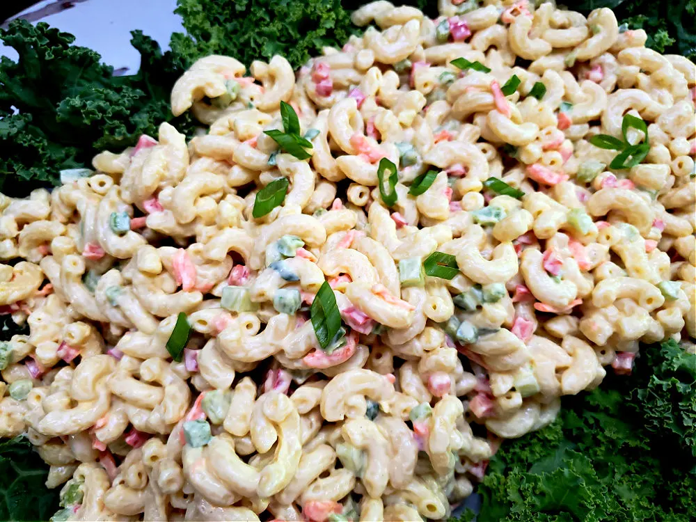 serving platter garnished with greens with macaroni salad