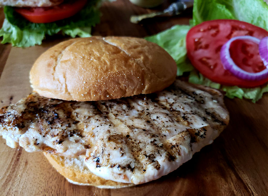Perfectly grilled boneless chicken breasts served on sandwiches with toppings