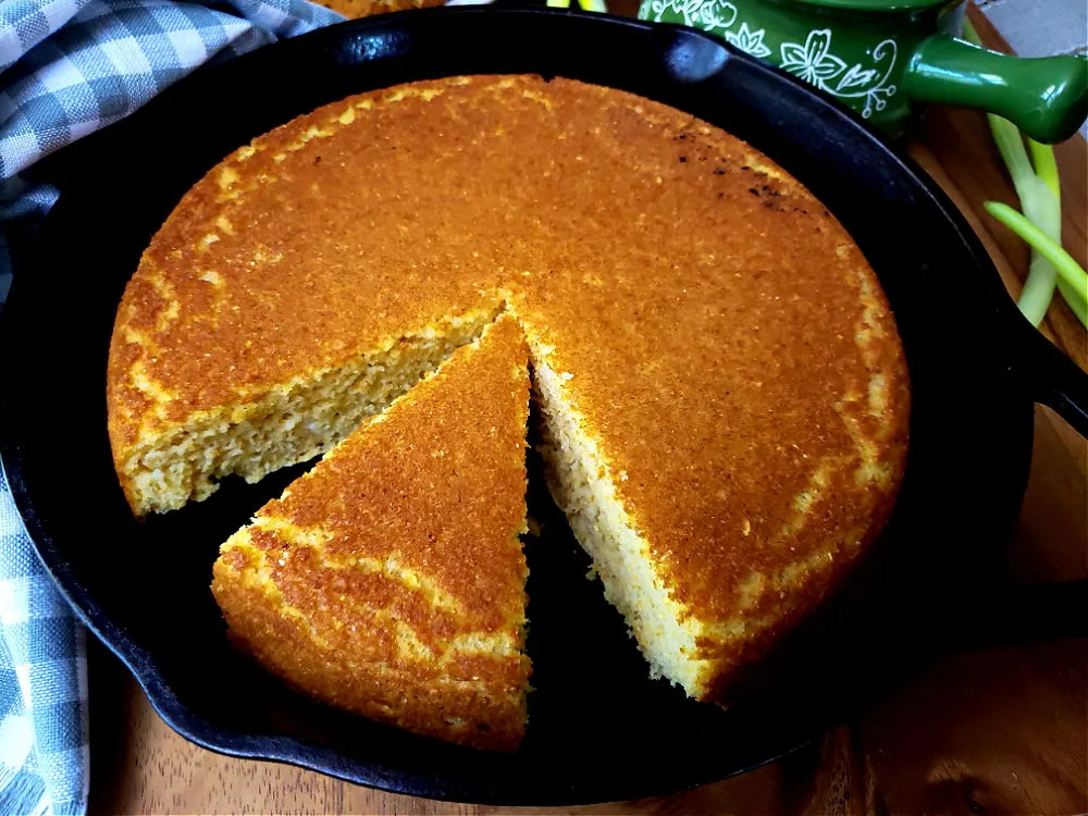 cake of Southern cornbread in a skillet sliced into wedges
