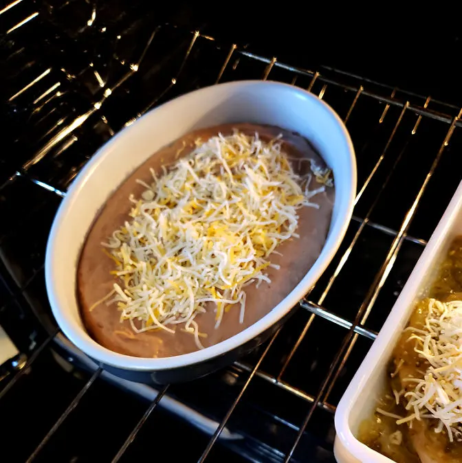 Refried beans topped with cheese in the oven