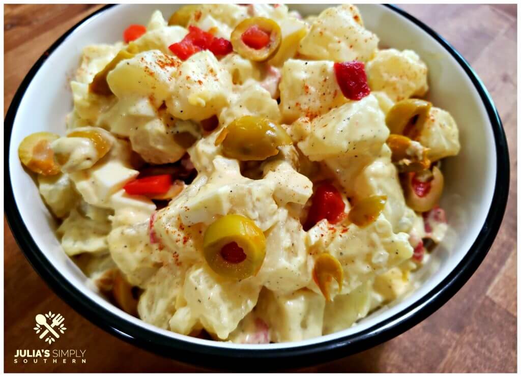 Potato Salad Recipe with olives in a black and white serving bowl