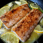 Two pieces of mahi mahi are being cooked in a skillet.
