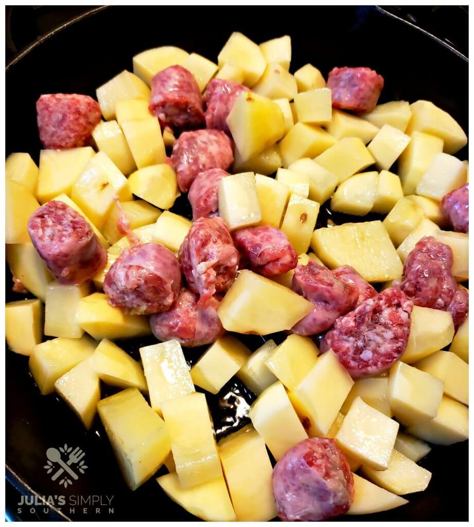 Raw potatoes and chopped bratwurst in a Lodge cast iron skillet ready for cooking