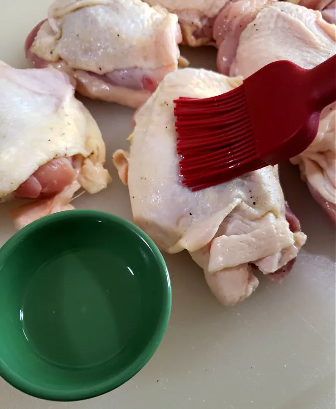 brush the chicken pieces with oil then season skin before baking