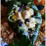 Fresh baked poblano pepper stuffed with chicken, cheese, corn and black beans and served on a bed of Spanish rice. The best stuffed pepper recipe with poblanos.