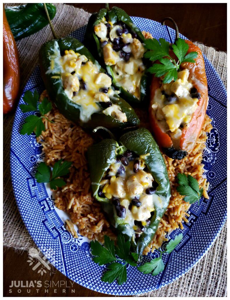 Blue and White Platter with Chicken and cheese stuffed poblano peppers on a bed of red spanish style rice garnished with parsley - Best stuffed peppers southwest style ever