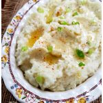 Cauliflower mashed mock potatoes recipe topped with melted butter and scallions