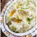 Cauliflower mashed mock potatoes recipe topped with melted butter and scallions