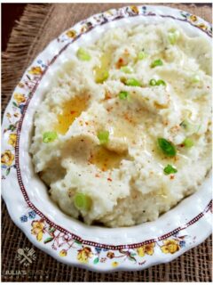Cauliflower mashed mock potatoes recipe topped with melted butter and scallions