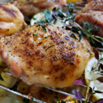 Recipes for chicken thighs: baked chicken thighs bone in with crispy skin and Greek seasoning on a rack lined sheet pan.