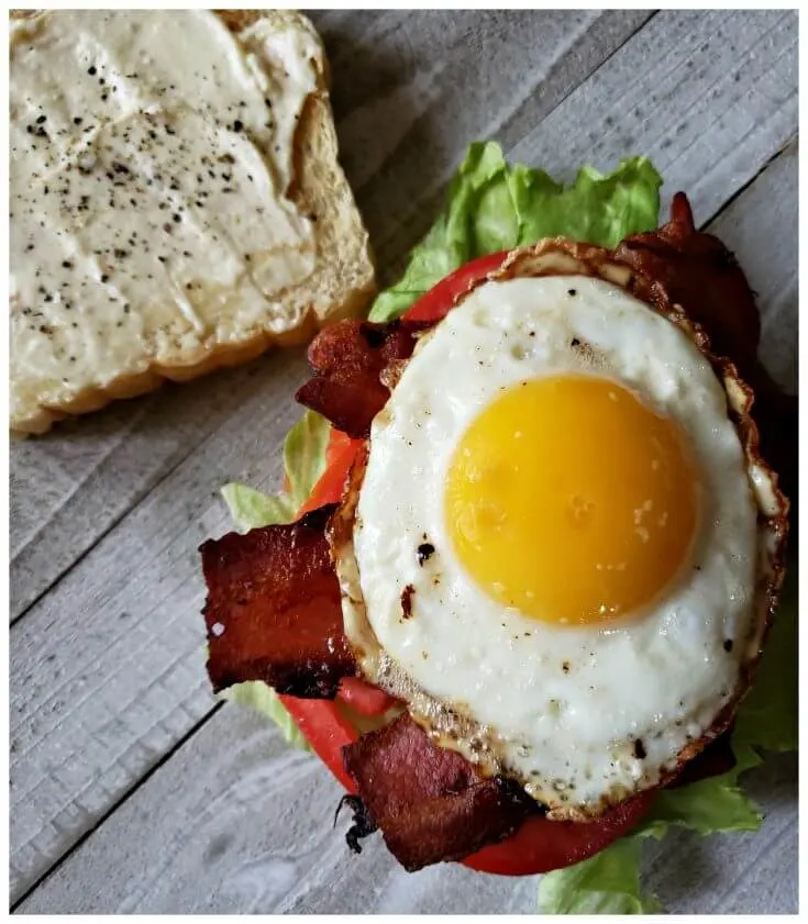 Best BLT Sandwich Recipe with fried egg for breakfast. The perfectly cooked egg with runny yolk sits on top of crispy bacon, crisp lettuce and a fresh vine ripe tomato on toasted bread for the ultimate breakfast.