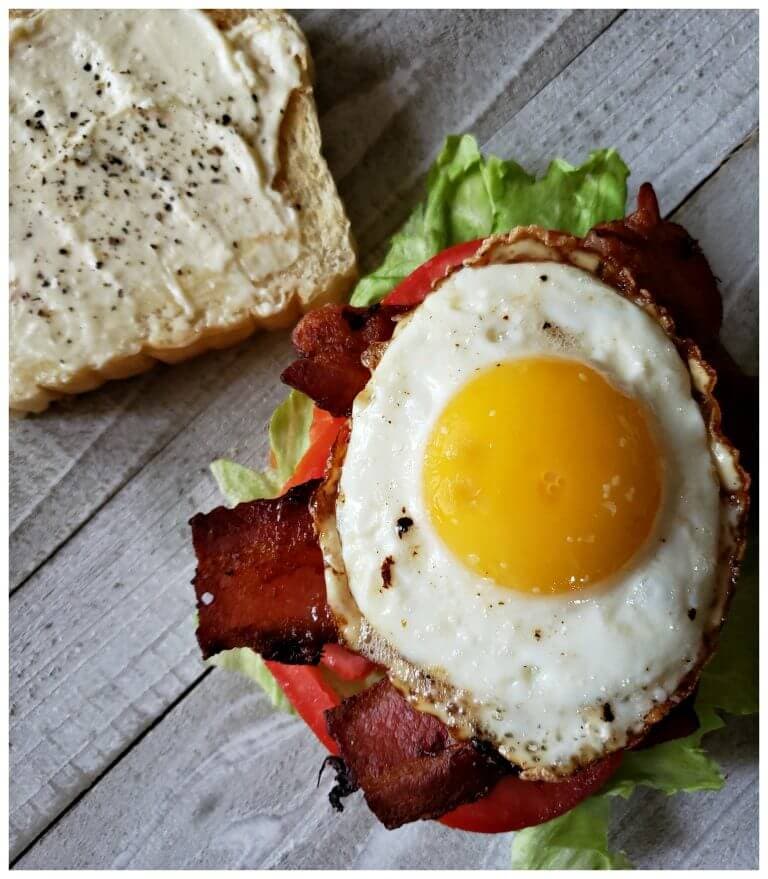 Best BLT Sandwich Recipe with fried egg for breakfast. The perfectly cooked egg with runny yolk sits on top of crispy bacon, crisp lettuce and a fresh vine ripe tomato on toasted bread for the ultimate breakfast.