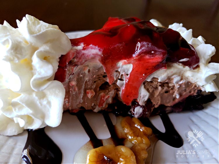 No Bake dessert - chocolate strawberry nut sundae pie on a plate with chocolate sauce, nuts and whipped cream garnish