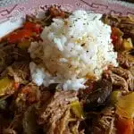 Crock Pot Fiesta Beef on a red and white china plate with rice