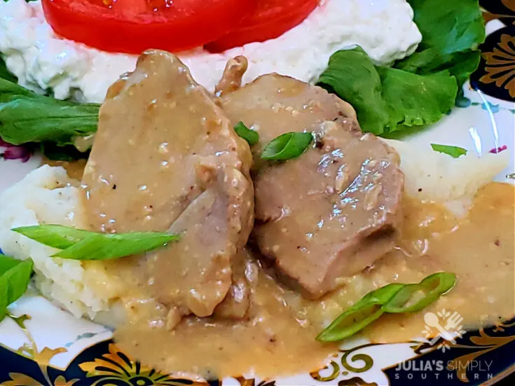 Crock Pot Pork Roast with Gravy on a bed of mashed potatoes with a cottage cheese salad