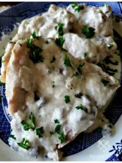 Tender baked pork chops smothered in cream of mushroom soup recipe garnished with parsley