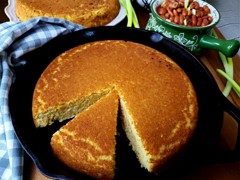 Easy Southern Cornbread recipe without buttermilk in a cast iron skillet with pinto beans in the background