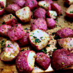 Easy roasted radishes recipe arranged on a copper colored sheet pan and garnished with parsley