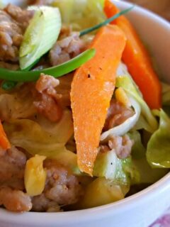 Low Carb Pork, Cabbage and Carrot Stir Fry on red and white china