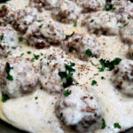 easy old fashioned meatballs and gravy recipe garnished with chopped parsley in a Lodge cast iron skillet