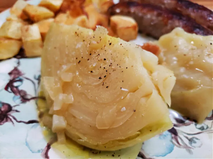the best old fashioned southern boiled cabbage recipe on a cotton boll pattern plate with fried potatoes and sausages