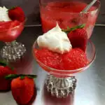 Old Timey Applesauce Salad Recipe with Jello and 7-Up served in a glass dessert dish with whipped topping and a fresh strawberry garnish
