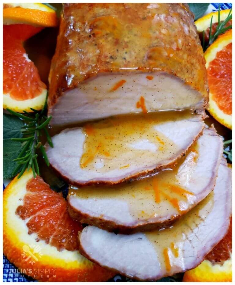 Easy oven roasted marinated pork roast with a fresh spiced orange sauce. This easy recipe is served on a platter garnished with fresh orange slices and topped with the orange sauce.