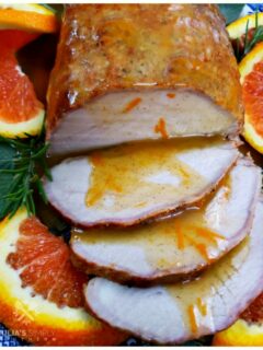 Easy oven roasted marinated pork roast with a fresh spiced orange sauce. This easy recipe is served on a platter garnished with fresh orange slices and topped with the orange sauce.