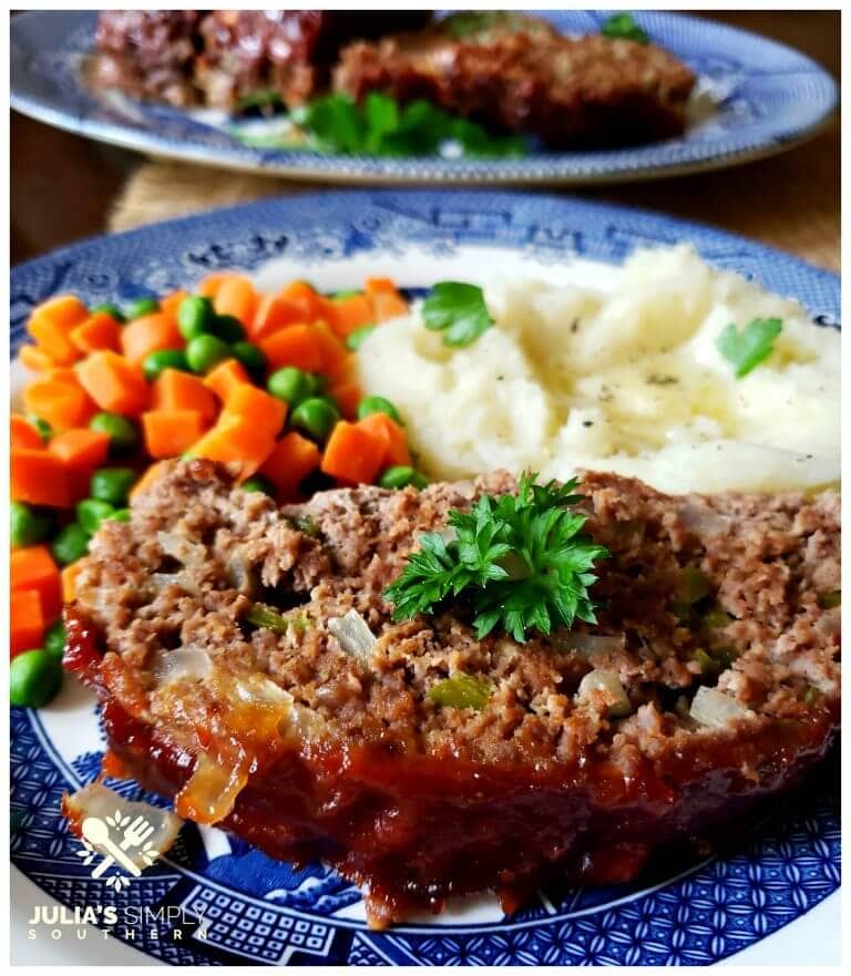 Classic Southern Meatloaf Recipe on a blue and white plate with mashed potatoes and peas and carrots