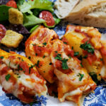 simple stuffed shells recipe with ricotta cheese served on a blue and white plate with a side salad and bread