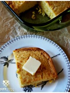 A wedge or rich and moist Southern cornbread on a plate topped with a pat of butter