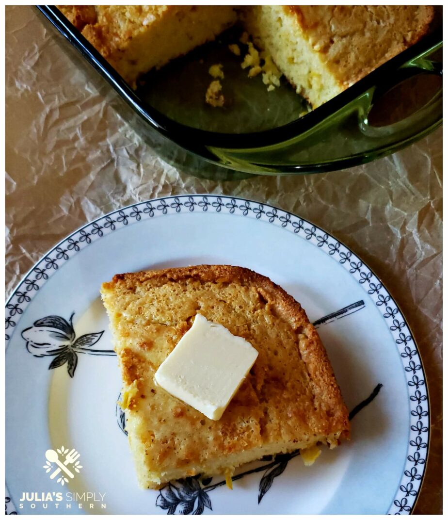 A wedge or rich and moist Southern cornbread on a plate topped with a pat of butter