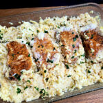 Easy baked pork chops and rice casserole recipe in a glass baking dish garnished with chopped parsley