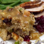 Southern Sausage, Apple, and Sage Cornbread Dressing served with turkey and string beans on a Thanksgiving plate