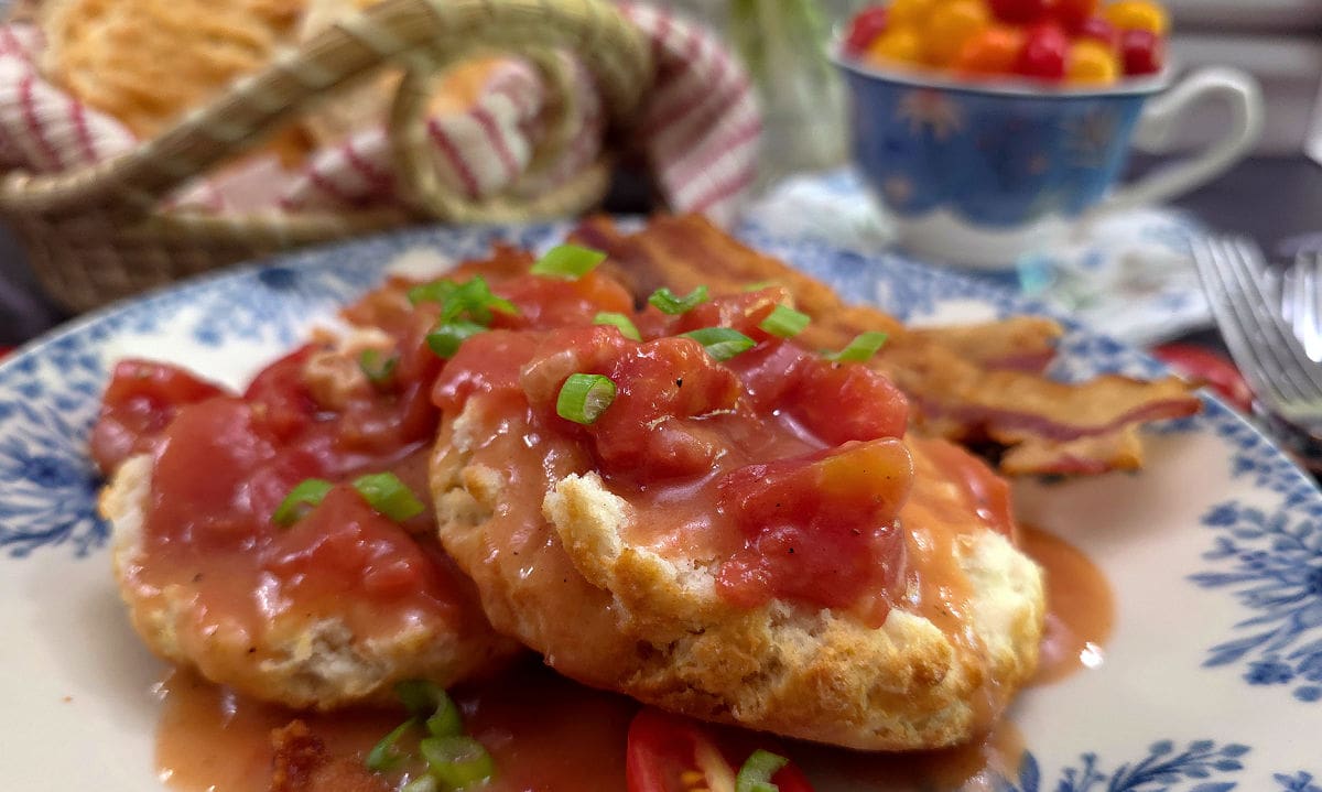 Southern Tomato Gravy Recipe (Old-Fashioned Country Tomato Gravy) served on a blue and white plate with biscuits and garnished with scallions