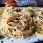 Simple Spaghetti with Olive Oil Recipe infused with garlic and red pepper flakes served on a white platter