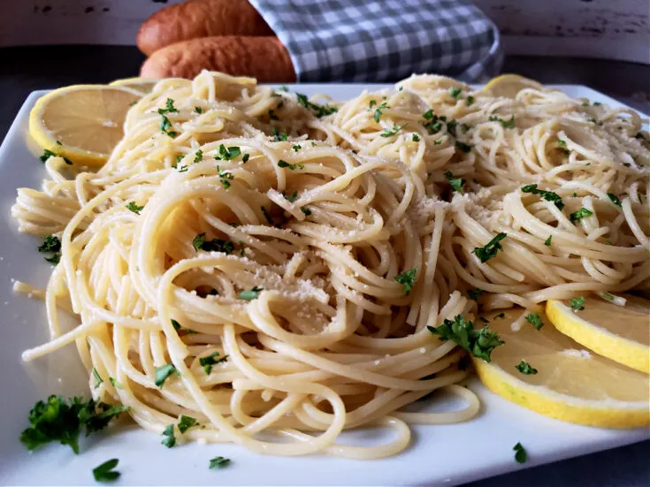 Simple Spaghetti with Olive Oil Recipe infused with garlic and red pepper flakes served on a white platter