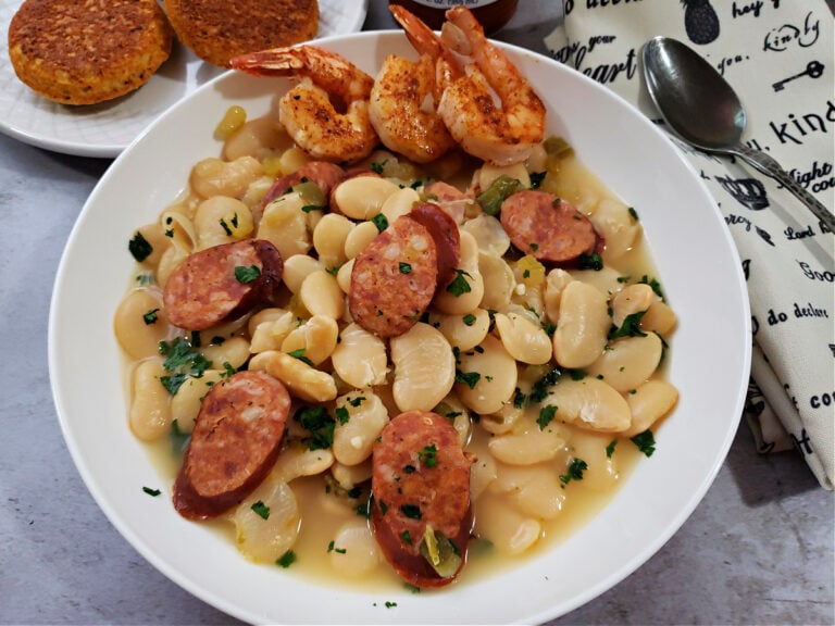 Down Home Southern Large Lima Butter Beans Recipe with slices of Andouille sausage and shrimp in a white bowl served with cornbread muffins