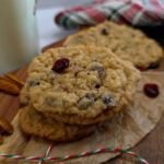 Southern Style Oatmeal Cranberry Pecan Cookies for Christmas Baking on a holiday cutting board with milk